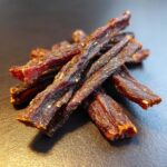 Close-up of a pile of Natural Beef Power Chew Sticks for dogs, showing texture and detail.