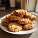 Pile of homemade Peanut Butter Oat Flour Dog Treats on a white plate, ready to be enjoyed.