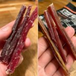 Close-up of Protein-Packed Beef Dog Chew Sticks held in a hand, showing texture and detail.