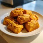 Pile of homemade Easy 3-Ingredient Pumpkin Peanut Butter Dog Treats on a white plate.