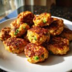 Close-up of a plate piled high with Salmon & Pea Homemade Dog Nuggets, showing peas.