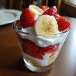 Close-up of a Strawberry Banana Pup Parfait with layers of yogurt, strawberries, and banana slices.