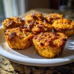 Close-up of baked Sweet Potato & Pumpkin Dog Mash Cups on a white plate.
